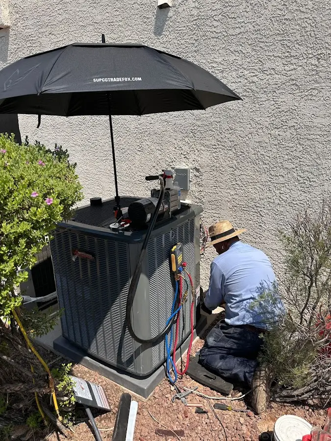 HVAC technician performing outdoor AC maintenance in Carpinteria